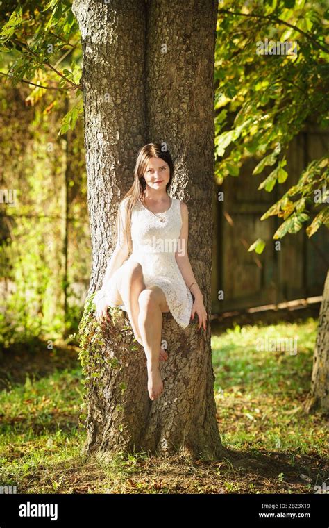 Beautiful Happy Girl In White Dress Sitting On A Tree Forest Nymph Stock Photo Alamy