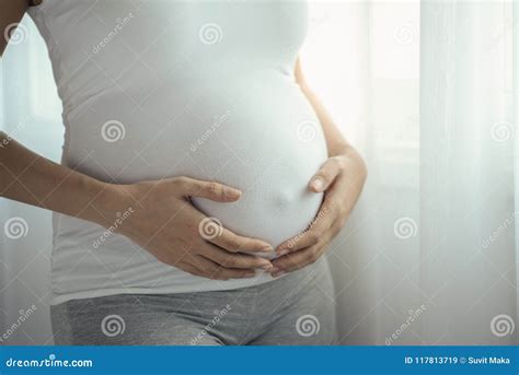 Young Pregnant Asian Woman Holds Her Hands On Her Swollen Belly Love