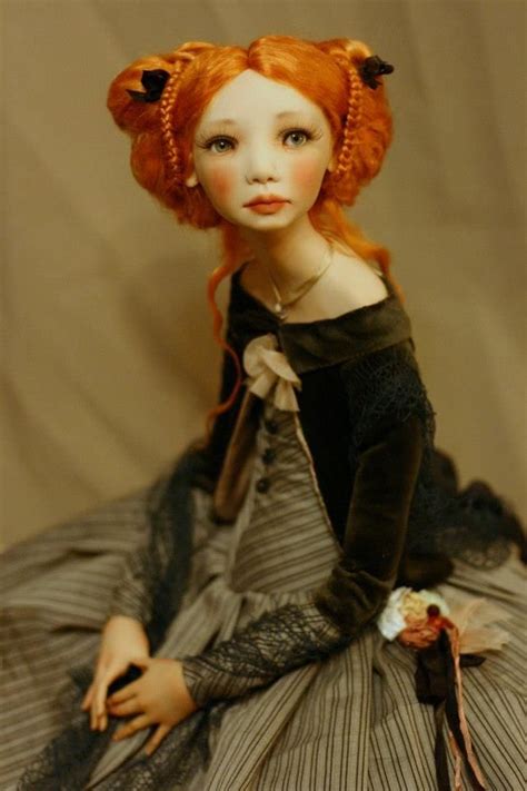 A Doll With Red Hair Sitting On Top Of A Bed