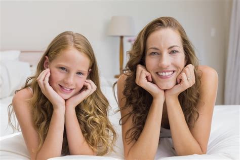 Sonriente Madre E Hija Acostada En La Cama Foto Premium