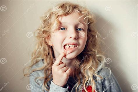 Cute Caucasian Blonde Girl Showing Her Missing Tooth In Mouth Proud