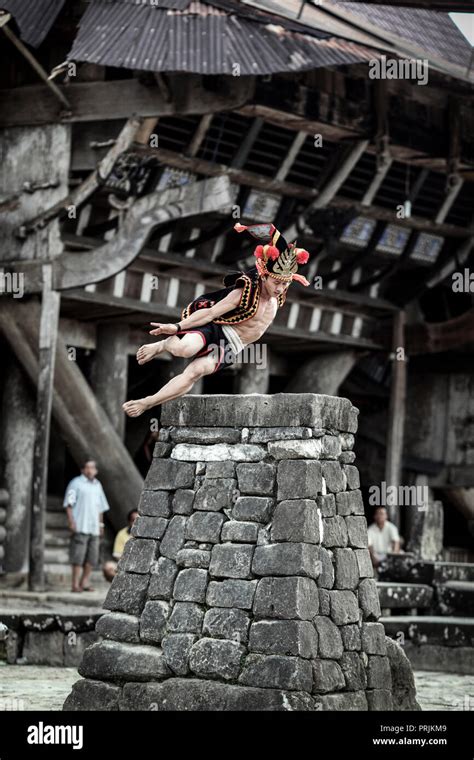 Man In Traditional Attire Stone Jumping Over Rock Platform On Nias Island Sumatra Indonesia