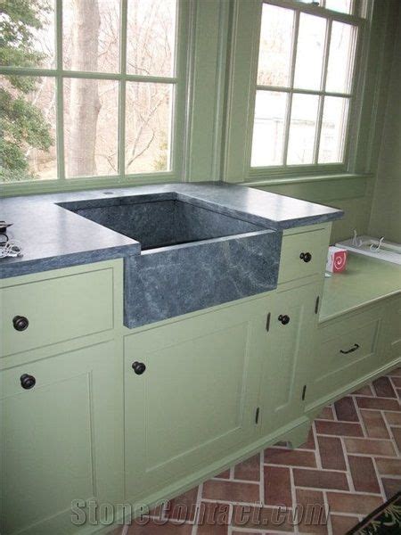 A Kitchen With Green Cabinets And A Large Sink In The Center Next To A