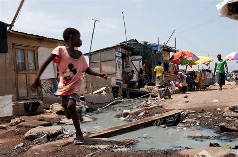 A Child Runs Across A Makeshift Bridge In Old Fadama Located In Ghana