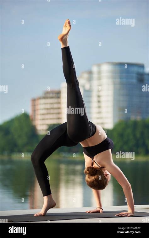 Young Attractive Yogi Girl Doing Yoga Standing In Bridge Exercise One