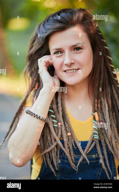 Beautiful Caucasian Cool Girl With Dreadlocks Pierced Nose In A Yellow