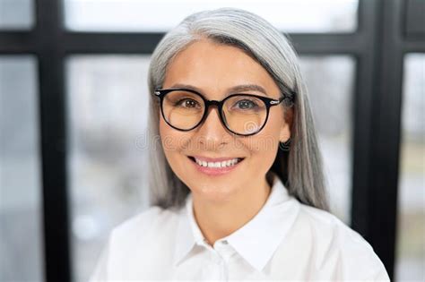 Headshot Of Confident And Smiling Old Senior Business Woman Wearing Glasses Looking At The