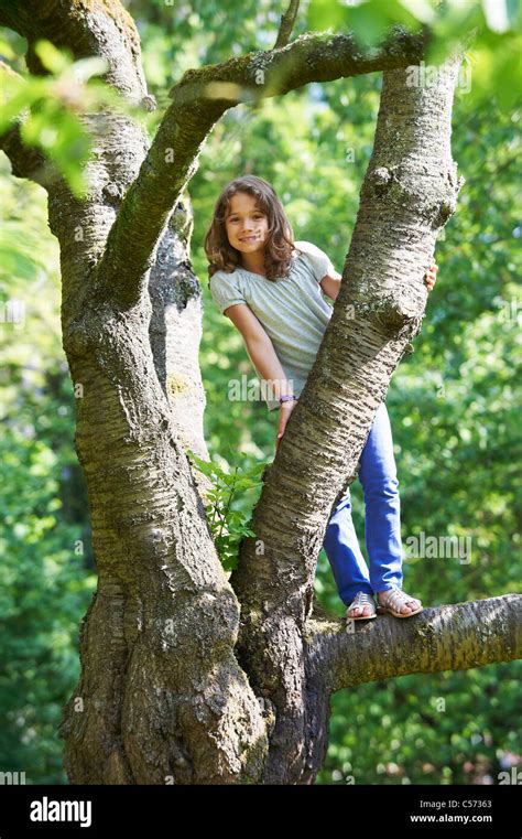 Smiling Girl Climbing Tree Outdoors Stock Photo Alamy