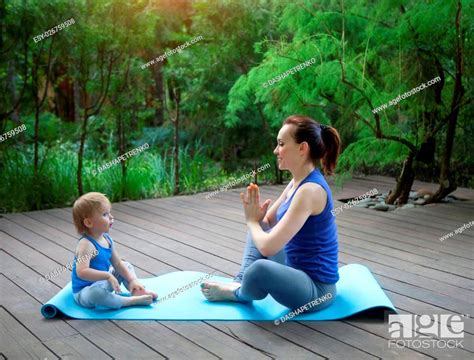 Mother And Babe Doing Exercise Practicing Yoga Outdoors Stock Photo Picture And Low Budget