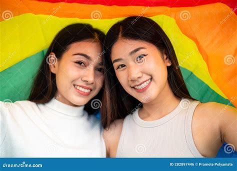 Smiling Asian Couple Looking At Camera In Rainbow Flag Protesting To Show Support Lesbian