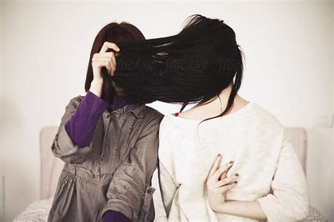 Woman Hides Her Face Behind Friends Long Hair By Stocksy Contributor Laura Stolfi Stocksy