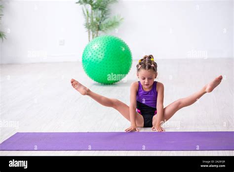 The Little Girl Gymnast Doing Exercises Indoors Stock Photo Alamy