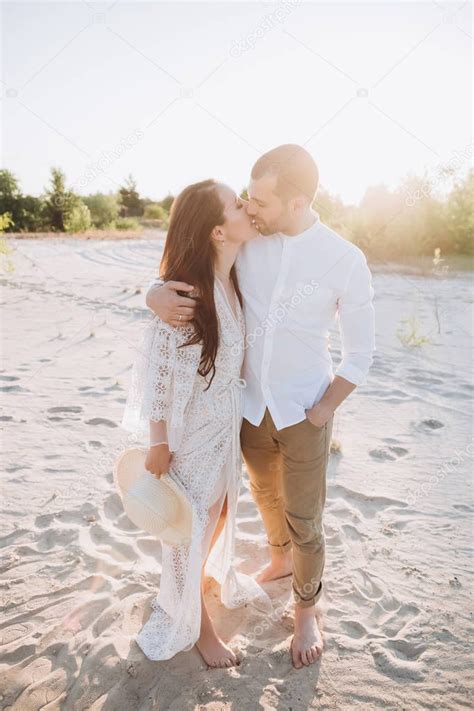 Счастливая пара обнимается и целуется на пляже с подсветкой 199941468 Ларасток