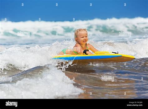 Little Baby Girl Young Surfer With Bodyboard Has A Fun On The Small