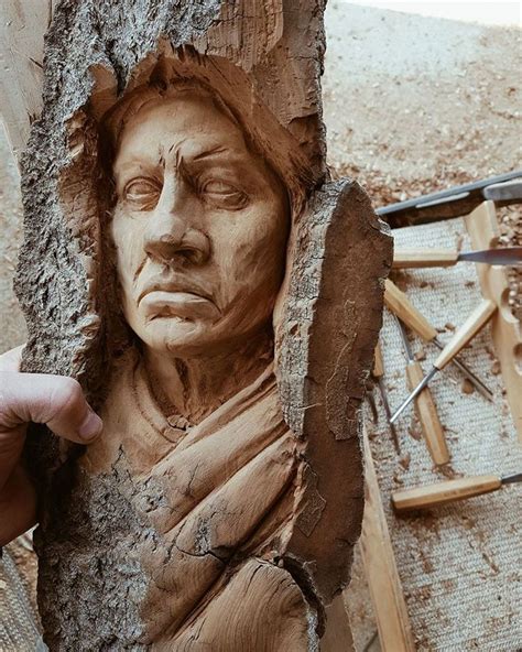 A Person Is Making A Clay Face Out Of A Piece Of Driftwood And Wood
