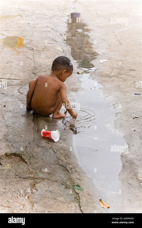 Jeune garçon asiatique cambodgienne nu jouant dans une flaque d eau