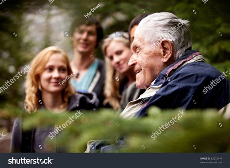 An Elderly Man Telling Stories To A Group Of Young People Stock Photo