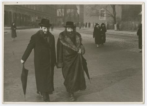 A Rabbi And His Disciple Walk Down A Street In Poland Collections