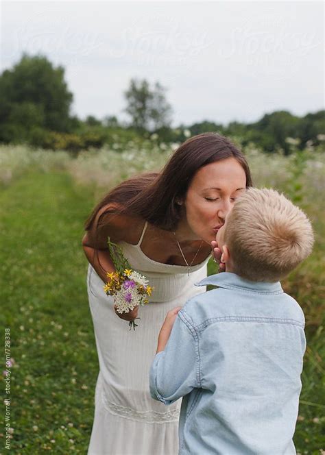 Mother Kisses Son After He Gives Her A Bouquet Of Wildflowers By