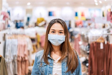 Young Asian Woman Wearing Surgical Mask Shopping In Clothes Stores At The Mall New Normal And