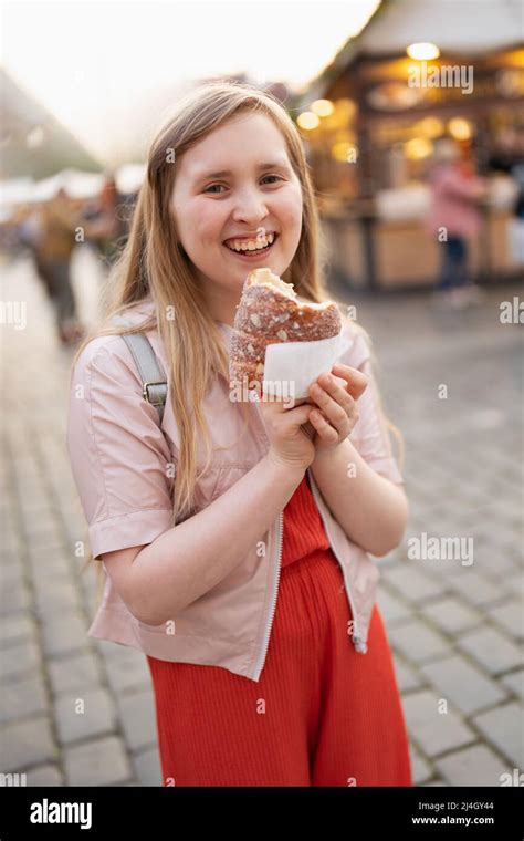 Portrait Of Smiling Modern Girl At The Fair In The City Eating Trdelnik