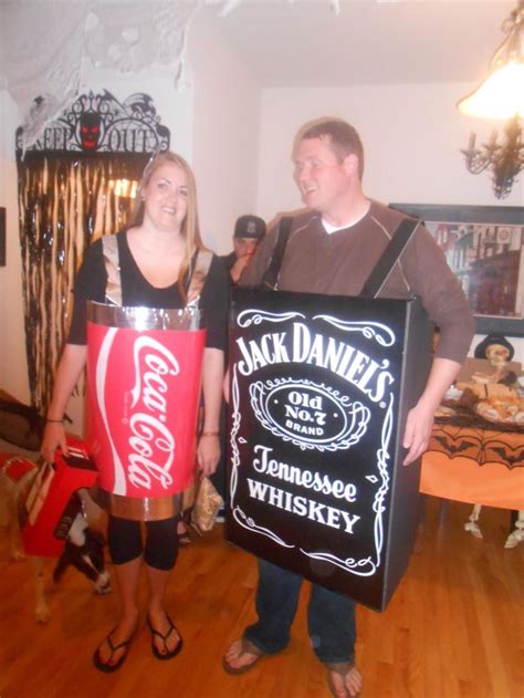 A Man And Woman In Costumes Holding A Sign