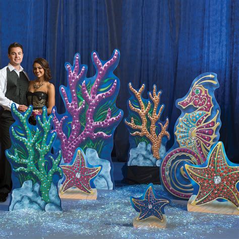 A Man And Woman Standing In Front Of Colorful Sea Life Sculptures With