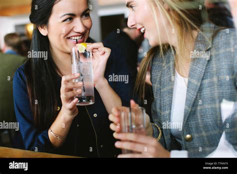 Happy Friends Talking While Having Drinks In Restaurant Stock Photo Alamy