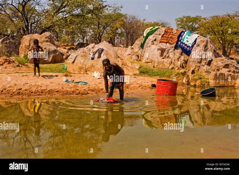 Inhabitants Of Northern Namibia Washing Clothes At A Small River Near