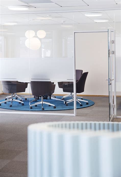 An Office Cubicle With Chairs And A Round Blue Rug In The Middle Is Shown