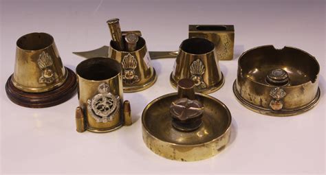 A Small Collection Of Brass Trench Art Some With Applied Military Badges
