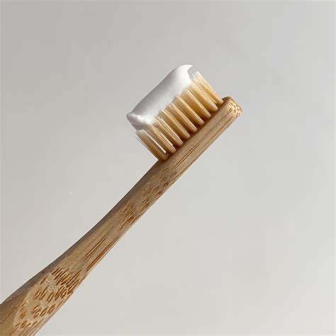 A Wooden Toothbrush With A White Bristles On It