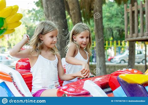 Two Tween Girls Riding On Amusement In Playground In Funpark Stock