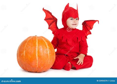 Little Boy In Red Devil Costume Sitting Near Big Pumpkin Royalty Free
