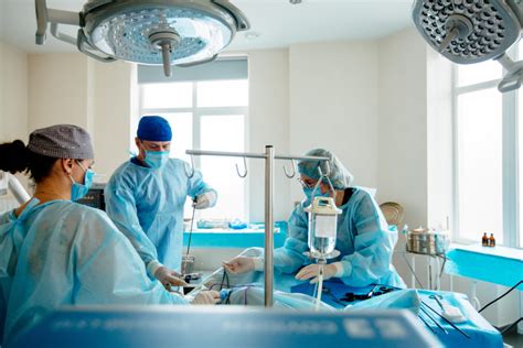 Surgeons Team Preforming Operation In Hospital Operating Theater Male