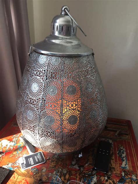 Himalayan salt lamp on table against dark background. Himalayan salt lamps can be potentially fatal for cats and ...