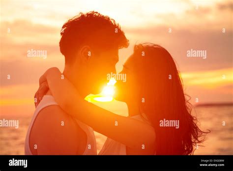 Young Couple Kissing At Sunset On Beach Stock Photo Alamy