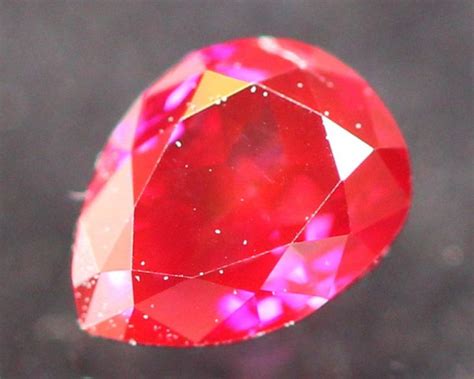 A Red Diamond Is Shown In This Close Up Photo With Water Droplets On