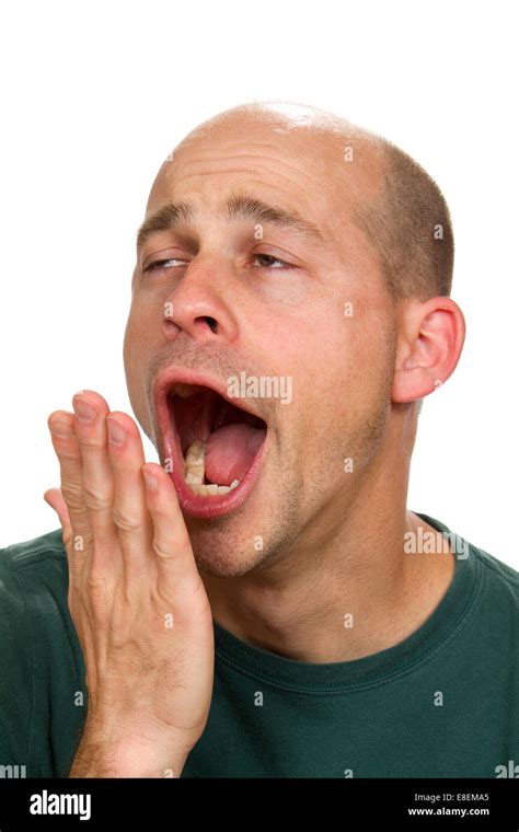 Man Covers His Mouth With His Hand As He Yawns With A Funny Expression