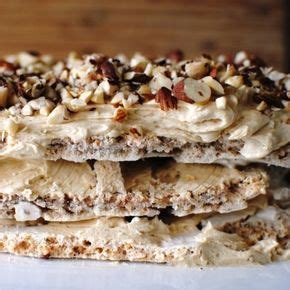 A Stack Of Desserts Sitting On Top Of A White Tablecloth Covered In Nuts