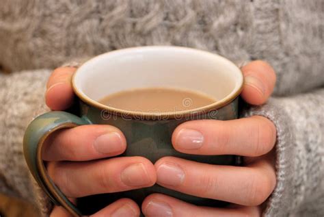 Two Hands Keeping Warm Holding A Hot Cup Of Tea Or Coffee Stock Image