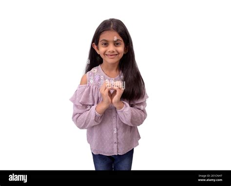 Portrait Of A Cute Little Indian Girl With Long Hair Showing Heart Shape Sign With Hands And