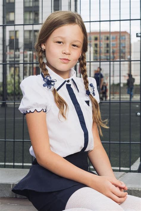 Colegiala En El Uniforme Que Espera El Autobús A La Escuela Foto De