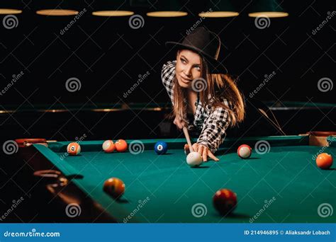 A Girl In A Hat In A Billiard Club With A Cue In Her Hands Hits A Ballplaying Billiards Stock