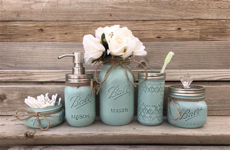 Blue Mason Jars With White Flowers And Soap Dispensers On A Wooden Shelf