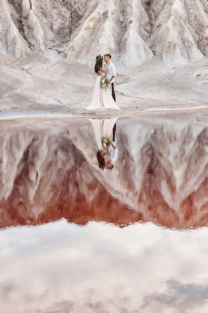 Pareja de enamorados abrazándose en el contexto de las montañas y el lago rojo Foto Premium