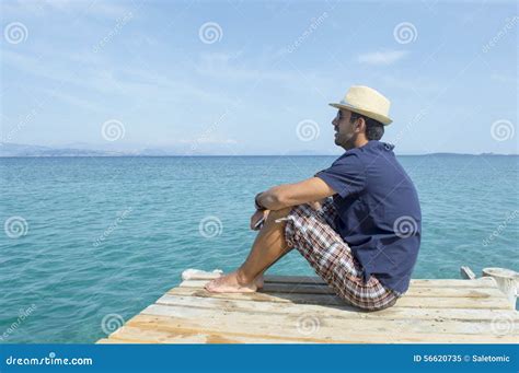 Young Man Sitting On The Dock Looking At Blue Sea Stock Image Image
