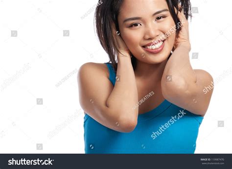 Cropped Head And Shoulders Portrait Of An Attractive Young Asian Girl Standing With Her Hands In