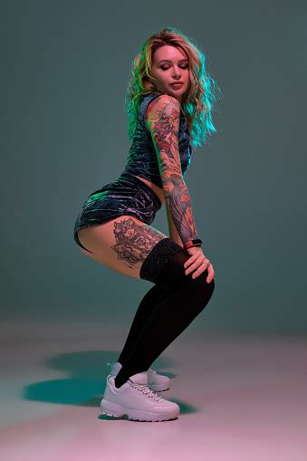 Sexy Blond Woman With Tattoed Body And Long Curly Hair Is Dancing Twerk