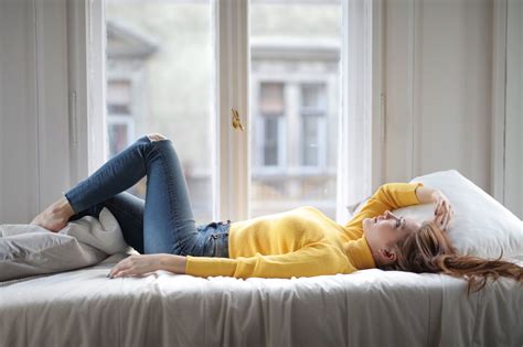 Relaxed Young Lady Resting On Bed Near Window In Light Bedroom · Free